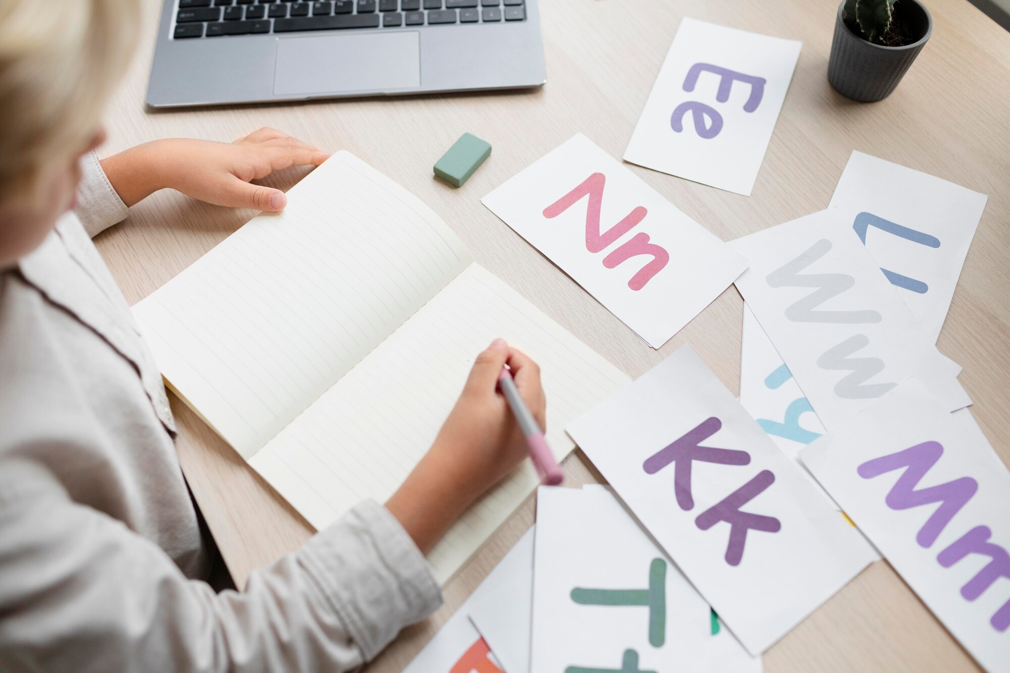 Enfant travaillant sur des lettres et un cahier, illustrant un bilan neuropsychologique avec le test Alouette-R pour l'analyse de la lecture et de la dyslexie, réalisé par Florence Ronco, neuropsychologue à Paris 5.