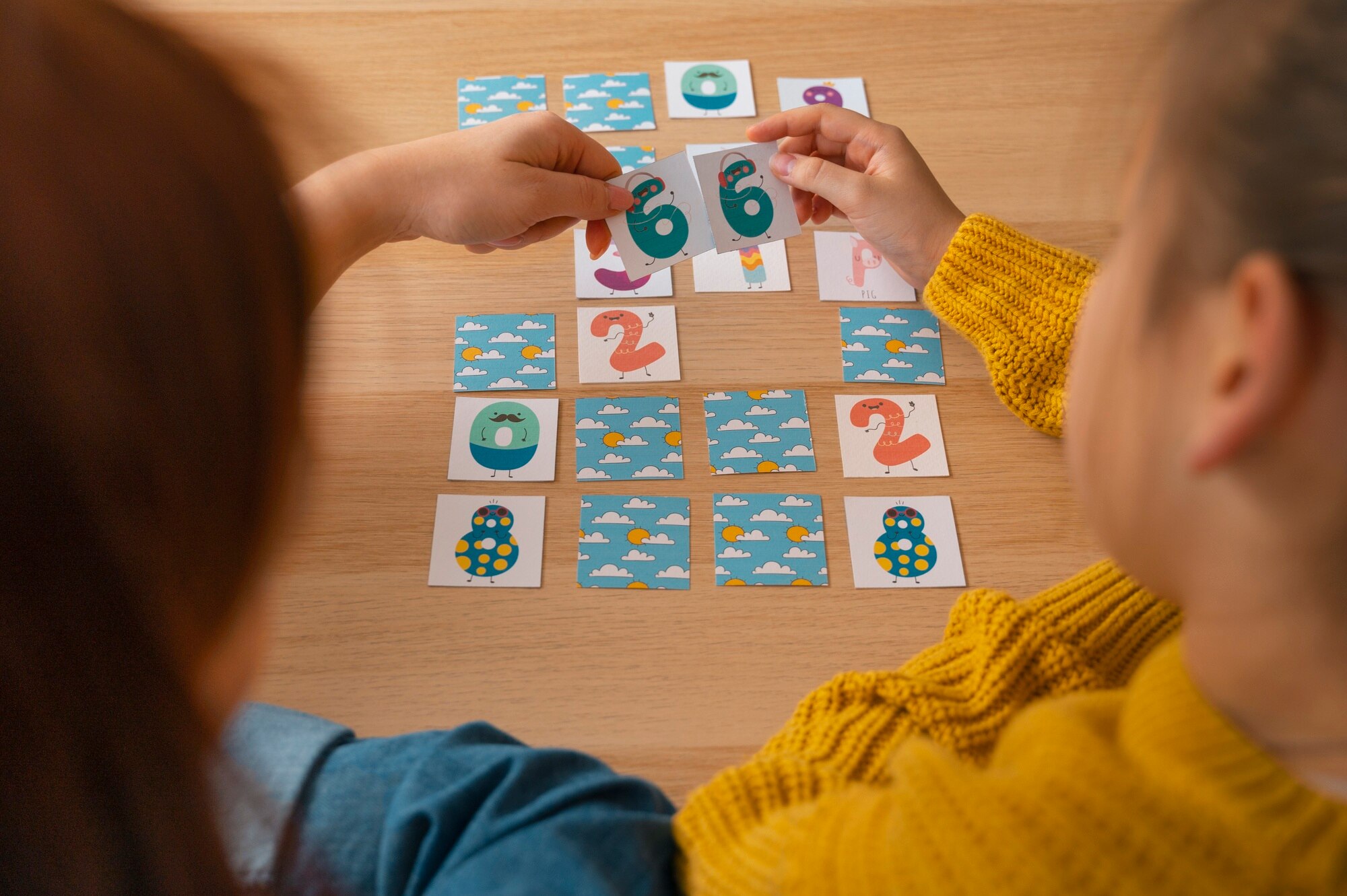 Deux enfants jouant à un jeu de mémoire avec des cartes colorées, illustrant un bilan neuropsychologique avec la CMS (Échelle de mémoire pour enfants, 2001) réalisé par Florence Ronco, neuropsychologue à Paris 5.