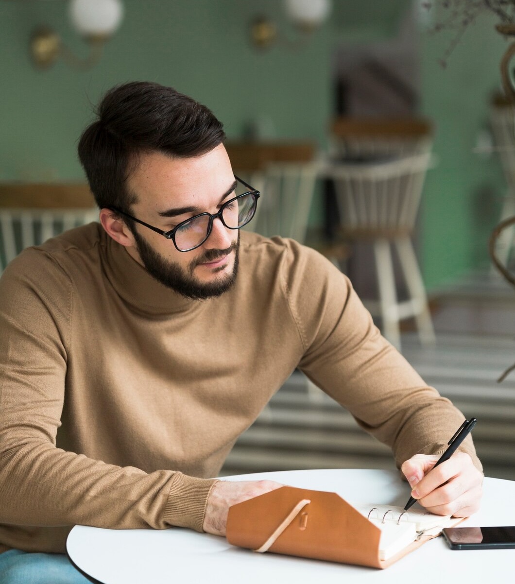 Homme concentré en train d’écrire dans un carnet, illustrant un bilan neuropsychologique avec le D2R (Test d’attention concentrée révisé, 2014, R. Brickenkamp) réalisé par Florence Ronco, neuropsychologue à Paris 5.