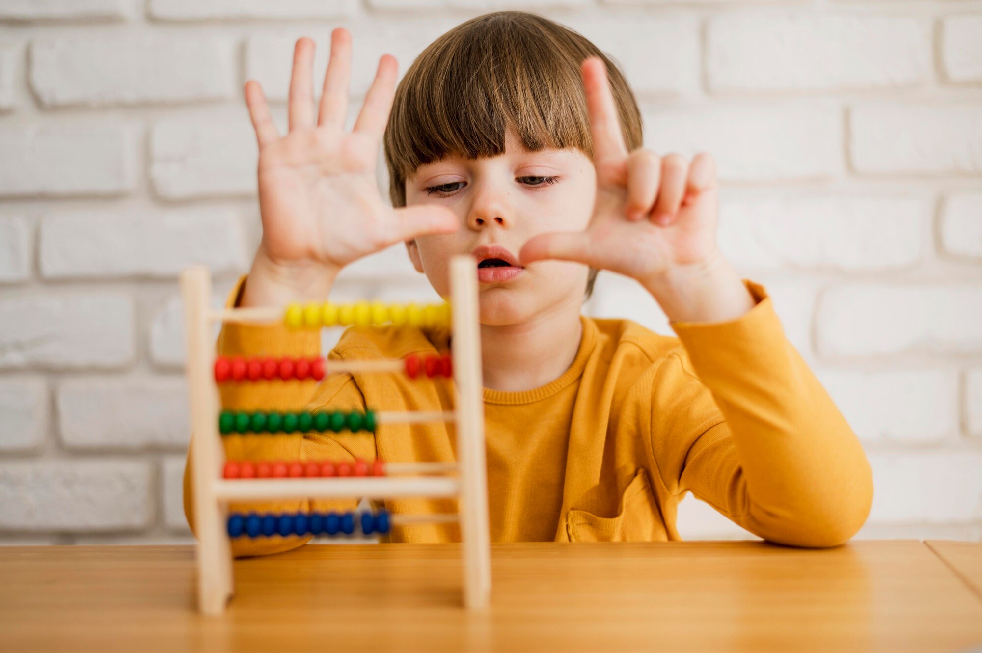 Enfant utilisant un boulier pour apprendre à compter, illustrant un bilan neuropsychologique avec l'UDN-II (Construction et Utilisation du Nombre, 1999) réalisé par Florence Ronco, neuropsychologue à Paris 5.